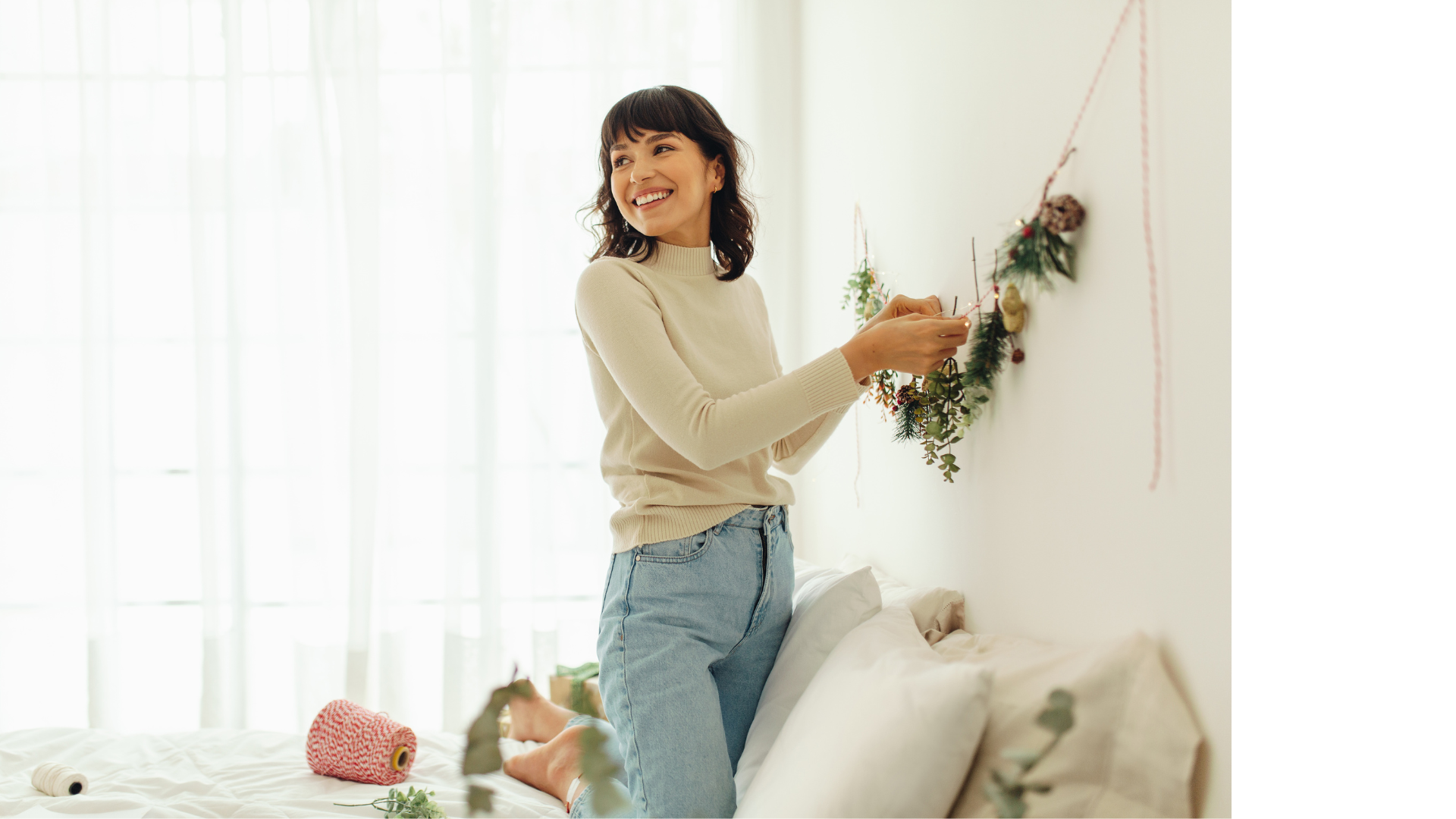 woman hanging up decor on the wall in the living room